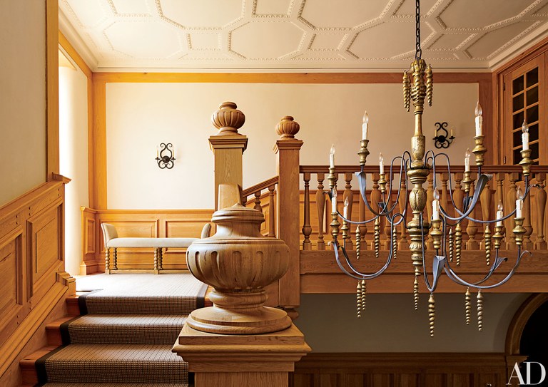 A Chandelier Hanging In A Room With Wooden Stairs