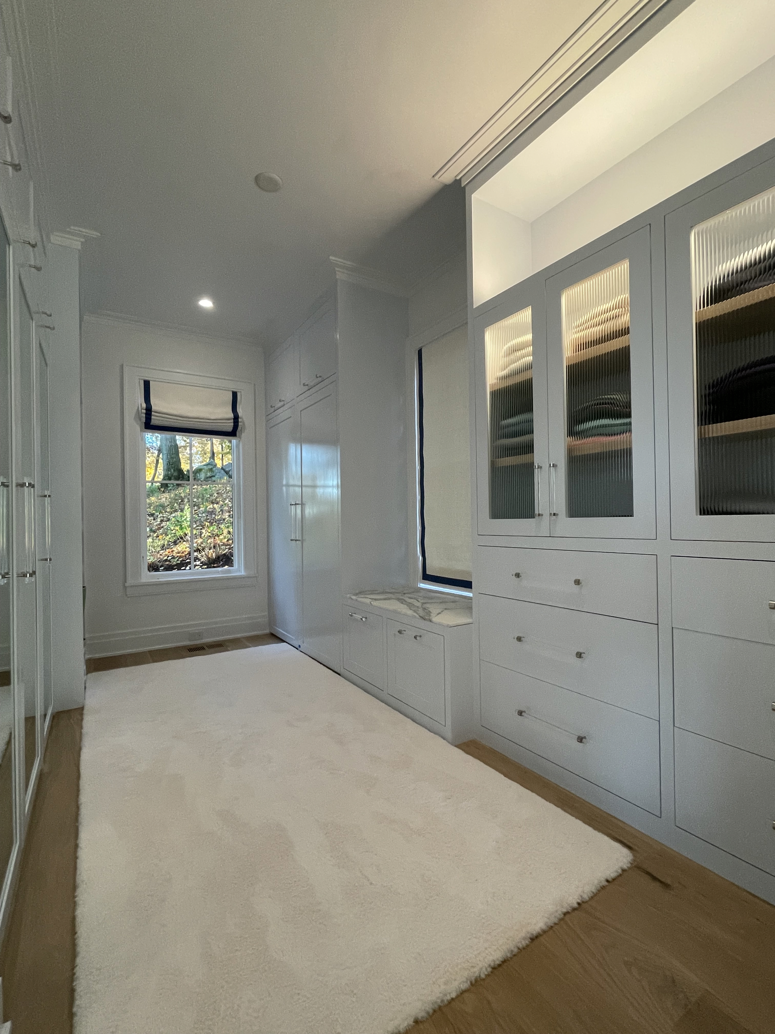 Walk-in Closet With White Carpet And Cabinets