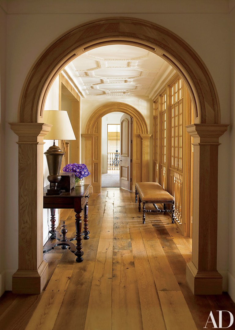 A Hallway With Wooden Floors And Arched Archways