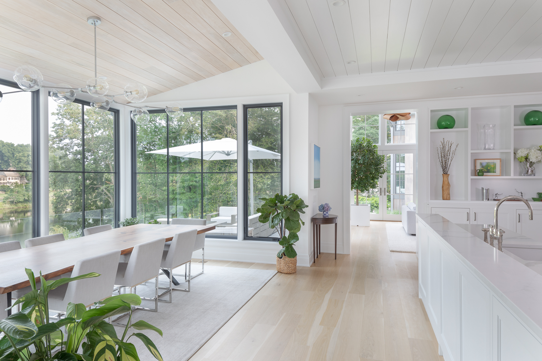 A Well-lit Kitchen With A Wooden Dining Table And Chairs