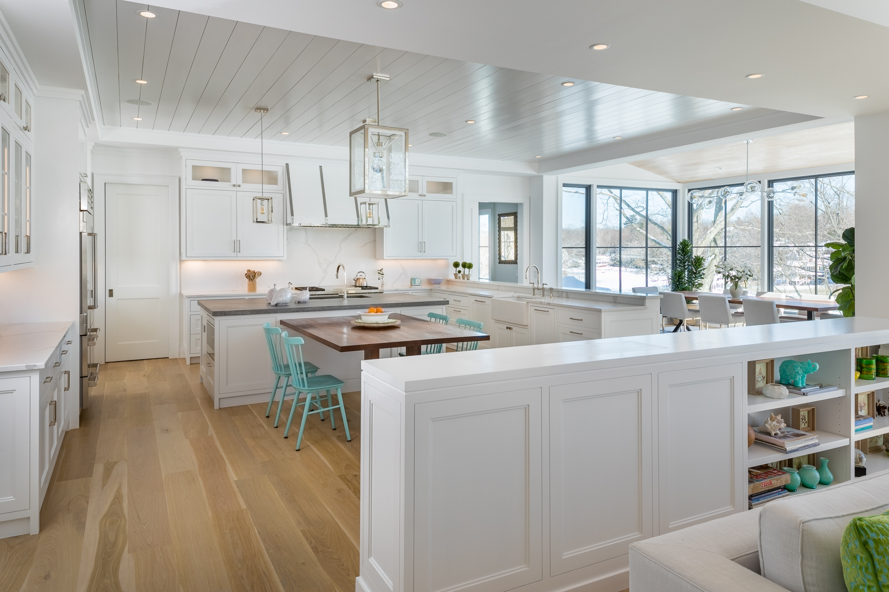 A Kitchen With A White Island And A Dining Area