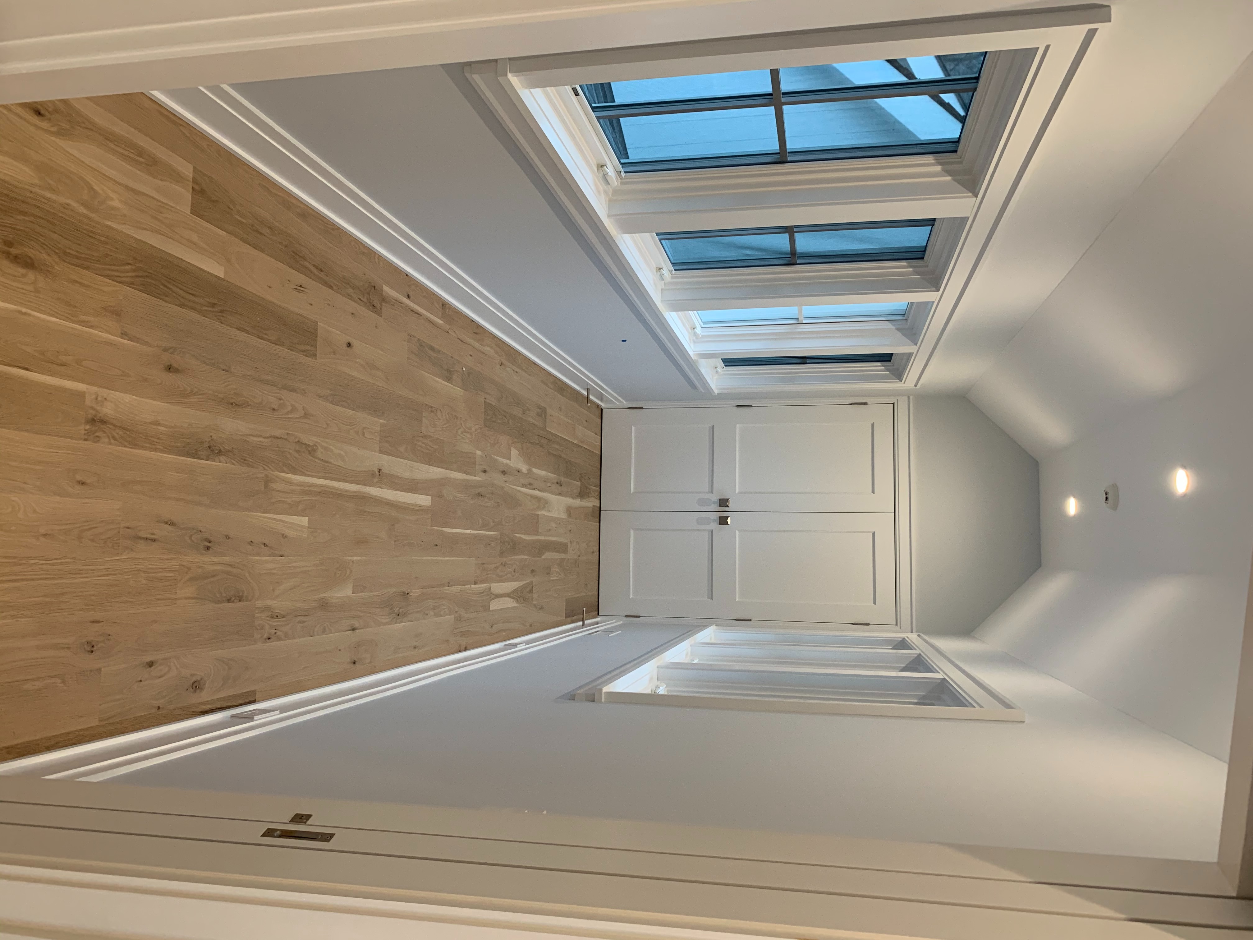 A Well-lit Hallway With Polished Wood Floor